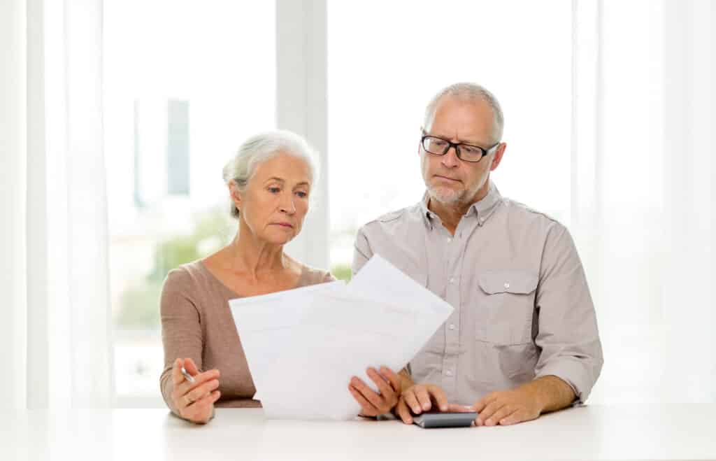senior couple with papers and calculator at home